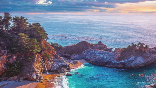A coastal landscape with rocky cliffs, a beach, and a clear view of the ocean. - Carmel’s HIGHEST RATED and Most ROMANTIC Getaway - Walk to Beach and Town (Carmel)