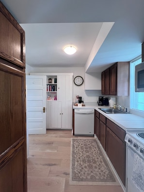 A kitchen with wooden cabinets, a white refrigerator, a clock, a microwave, and a dishwasher. - Private Colonial 3BR House with tub,kitchen, Fast Wi-Fi -2 min from the Inn! (Washington)