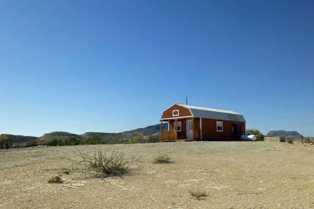 Un bâtiment d’un seul étage, doté d’un toit à pignon, d’un porche à l’avant et d’un petit garage attenant.