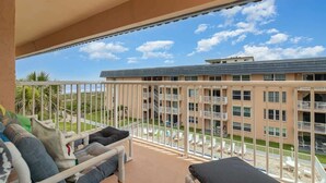 Ein Balkon mit Blick auf ein Gebäude und einen Strand.
