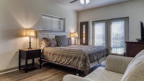 A bedroom with a bed, two bedside tables with lamps, a ceiling fan, and two windows with blinds. - Close to attractions - Inside and outside pool and hot tub! (Pigeon Forge)