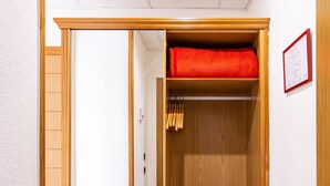 A wooden closet with a red towel and a framed certificate on the wall. - Negresco Gran Vía (Madrid)
