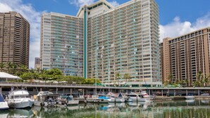 A marina with several boats docked, surrounded by high-rise buildings with balconies. - Deluxe Waikiki Ocean Front Suite - Ilikai (Honolulu)