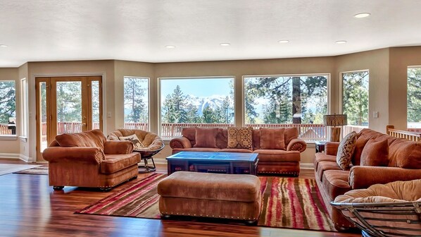 A spacious living room with a large sectional sofa, a coffee table, and a fireplace.