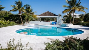 A swimming pool with a gazebo, palm trees, and a white building with a tiled roof. - Bijou! Sophistication and comfort in Turtle Cove (Providenciales)