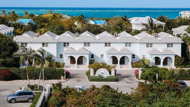 A coastal hotel with a symmetrical facade, multiple balconies, and a view of the ocean. - Bijou! Sophistication and comfort in Turtle Cove (Providenciales)