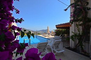 Una piscina al aire libre de temporada, sillones reclinables de piscina