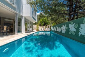 Una piscina al aire libre de temporada, sillones reclinables de piscina