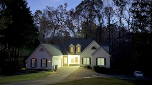 A two-story house with a driveway and a lawn.