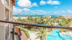 Un resort con piscina, palmeras y vista al océano.