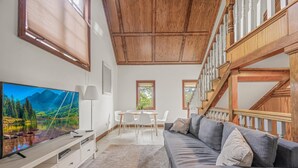 A living room with a TV, sofa, and dining area. - Castle like home in SW PDX, close to downtown! (Portland)