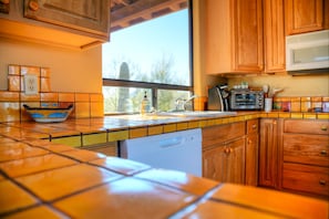A kitchen with wooden cabinets, a microwave, a toaster, and a dishwasher.