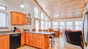 Una cocina amplia con armarios de madera, una isla grande y un comedor con sillas y mesa.