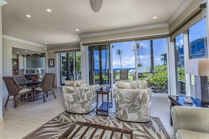 Relax in this spacious living area with a large dining table and comfortable seating for two.