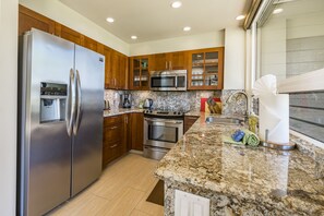 Enjoy cooking in this well-equipped kitchen with a refrigerator, microwave, oven, and sink.