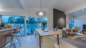 Eine moderne Küche mit einer großen Kochinsel, einer Bar und Blick auf einen Swimmingpool.