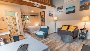 Una sala acogedora con sofá, sillón y una mesa de comedor con un libro.