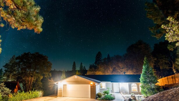 A house with a garage, a covered porch, and a well-maintained garden. - Riverside Manna, "Gateway to Beautiful Yosemite Valley" Modern 3bd/2 ba cottage (Mariposa)