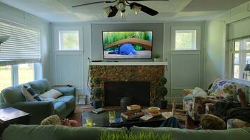 Smart-tv, een open haard, boeken en een computerscherm