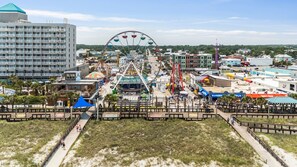 Ein Küstenamusementpark mit Riesenrad, Promenaden und verschiedenen Gebäuden.