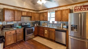 A kitchen with wooden cabinets, stainless steel appliances, and a ceiling fan.
