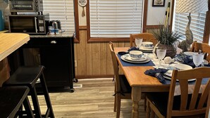 A dining area with a wooden table set for four, a microwave, toaster, and a small refrigerator. - 2 Bedroom / 2 Bath - Close to Everything! (Myrtle Beach)