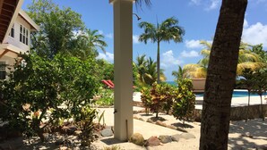 Un resort tropical con piscina, palmeras y una zona de playa arenosa.