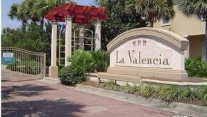 A sign for La Valencia with a red canopy and palm trees in the background. - Resort Home, 6 Bedrms,4.5bath, pool,Pet friendly, on Gulf,Gated (Panama City Beach)