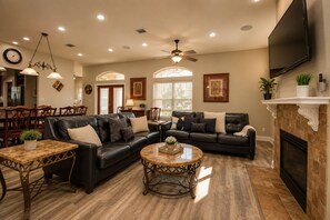 A living room with a sectional sofa, a coffee table, and a fireplace.