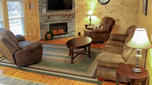 A cozy living room with a fireplace, a television, and comfortable seating. - Spacious Bobcat Cabin, 30 mins from Hocking Hills (Nelsonville)