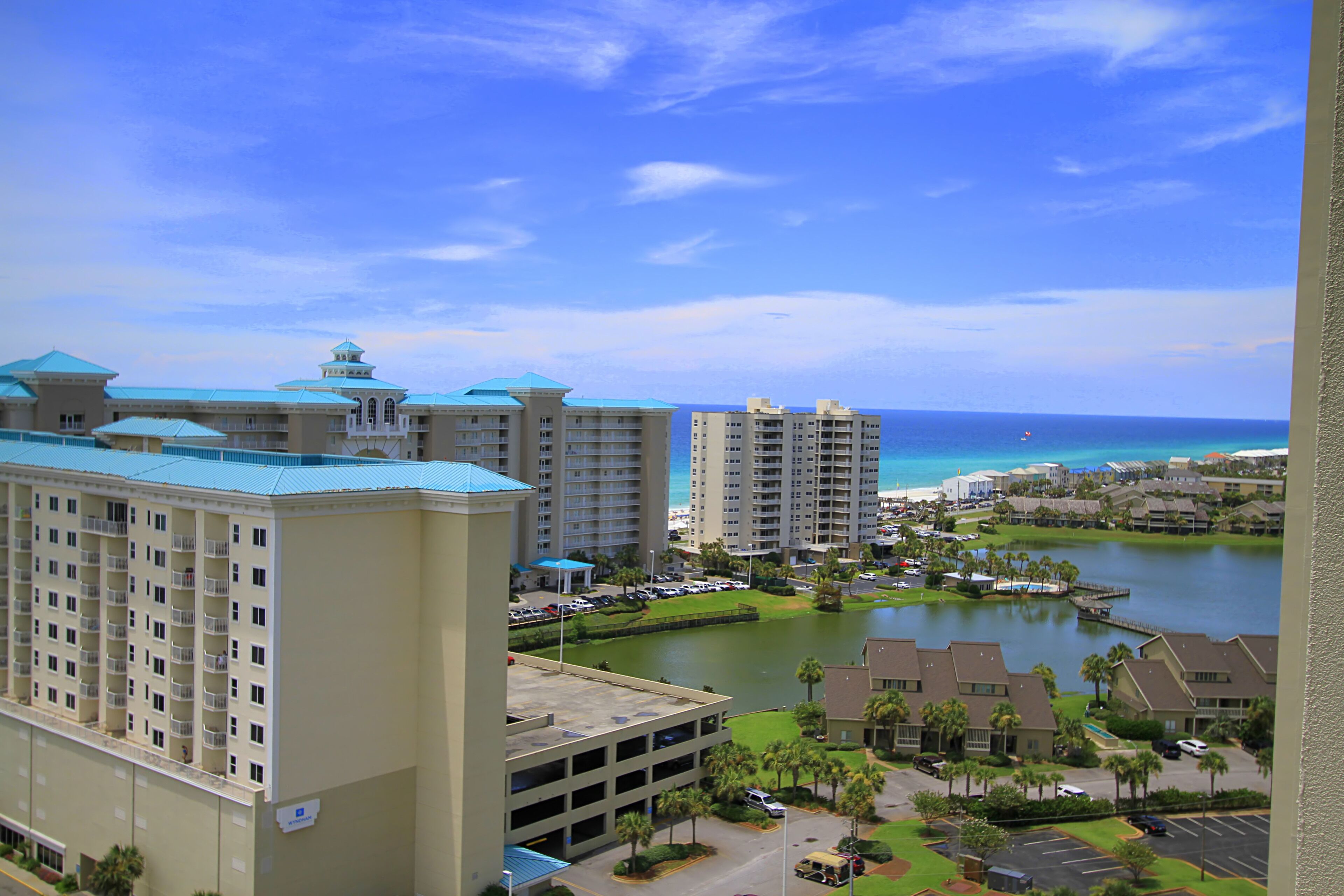 A high-rise hotel with multiple floors, a parking garage, and a view of the ocean.