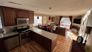 A spacious kitchen with wooden cabinets, a built-in oven, and a granite countertop. - This Is Our Completely Remodeled Place On The Lake! Right Next To Sdc! (Branson)