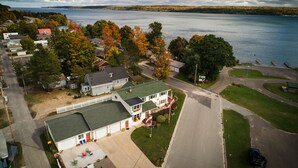 A residential area with houses, a driveway, and a lake in the background.
