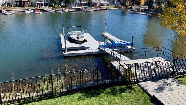A lakefront property with a dock, boats, and houses in the background. - Thanksgiving & Christmas-HEAVENLY-Waterfront-Mtn Views-HotTub-Pool Table-Dock (South Lake Tahoe)