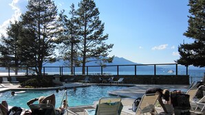 A pool area with lounge chairs and a view of the ocean. - Thanksgiving & Christmas-HEAVENLY-Waterfront-Mtn Views-HotTub-Pool Table-Dock (South Lake Tahoe)