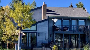 A dock with kayaks, a building with large windows, and a clear blue sky. - Thanksgiving & Christmas-HEAVENLY-Waterfront-Mtn Views-HotTub-Pool Table-Dock (South Lake Tahoe)