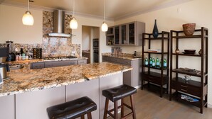 A modern kitchen with granite countertops, stainless steel appliances, and a central island with bar stools. - Luxury in Queen Anne very walkable! (Seattle)