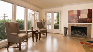 A spacious living room with large windows, a fireplace, and a view of the outdoors. - Luxury in Queen Anne very walkable! (Seattle)