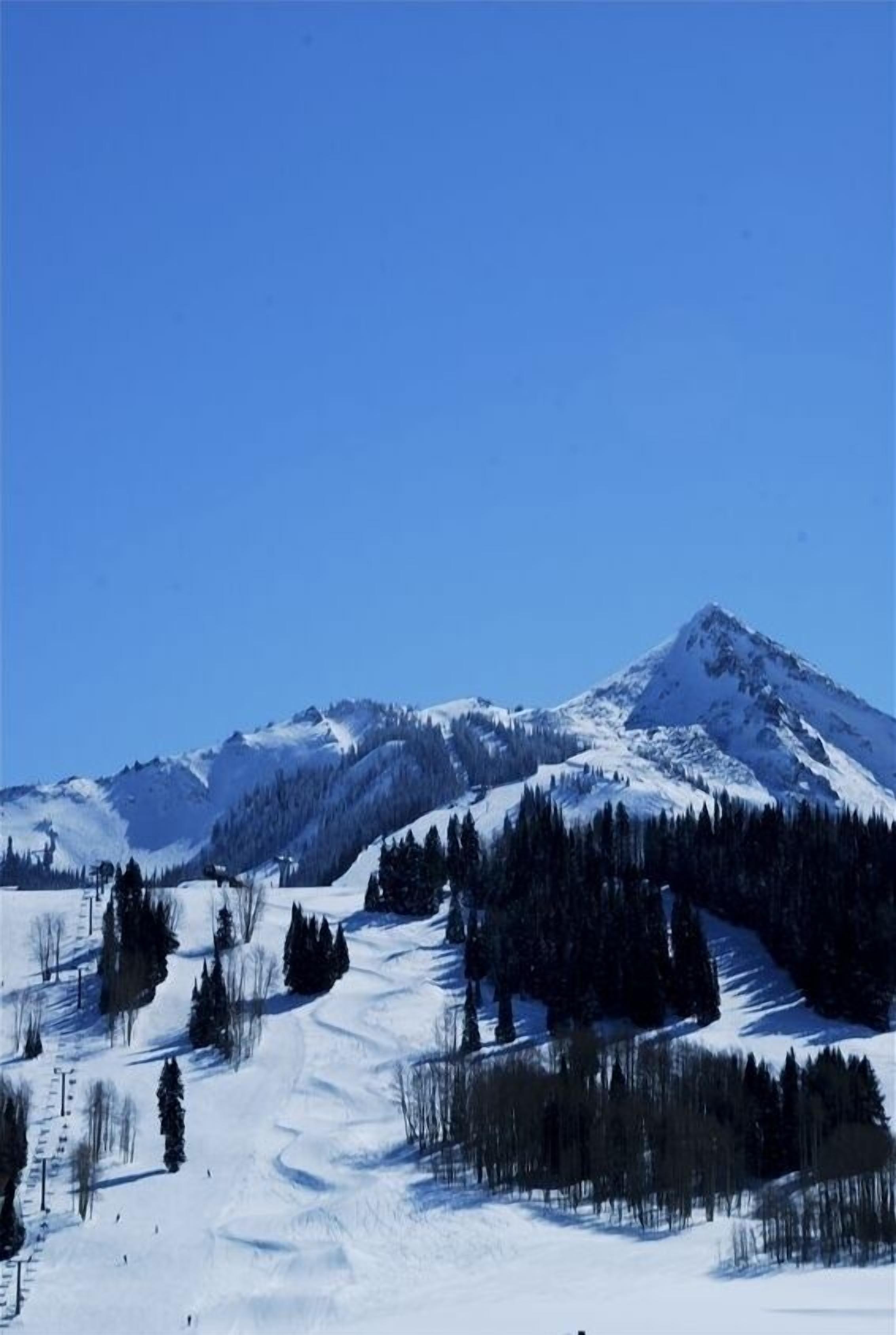 A snow-covered mountain landscape with a clear sky.