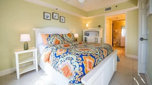 A bedroom with a bed, a nightstand, and a ceiling fan.