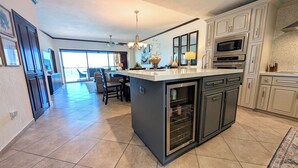 Una cocina moderna con una isla central, horno empotrado y electrodomésticos de acero inoxidable.
