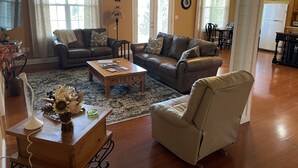 Un salon comprenant deux canapés, une table basse et un coin repas avec une table et des chaises.