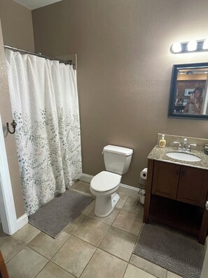 A bathroom with a toilet, sink, and shower curtain.
