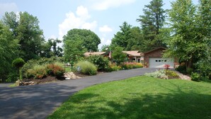 A residential property with a paved driveway, a garage, and a well-maintained lawn.