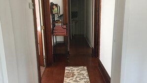 Un pasillo con suelo de madera y una alfombra estampada.