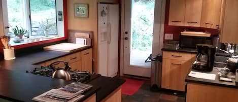Kitchen features gas stove with electric convection oven, an old farmhouse sink.