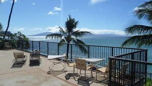 Une terrasse avec mobilier d’extérieur donnant sur une plage et l’océan.
