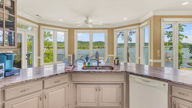 Una cocina con vista a un lago, un ventilador de techo y un lavavajillas.