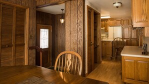 Un interior de madera con comedor, cocina y pasillo.