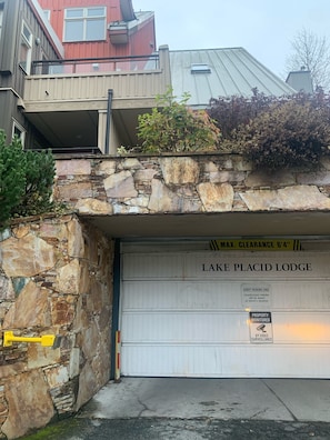 Entrada de garaje con un muro de piedra y un letrero que dice 'Lake Placid Lodge'.